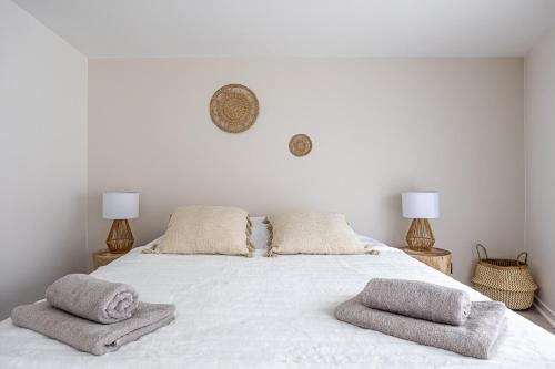 un lit blanc avec deux oreillers dessus dans l'établissement OIQIA • Téralis • Équinoxe, à Annonay