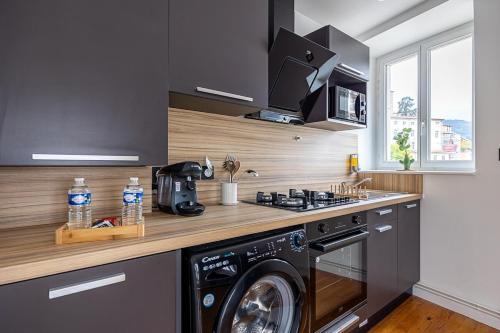 une cuisine avec un lave-linge et un micro-ondes dans l'établissement OIQIA • Téralis • Été Indien, à Annonay