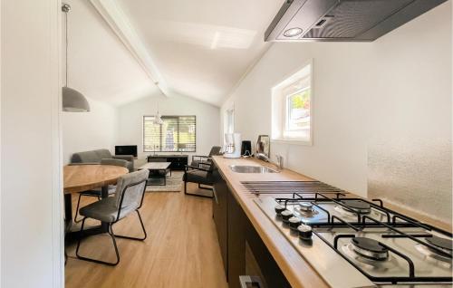 a kitchen with a stove top oven next to a living room at Stunning StaCaravan In Putten in Putten