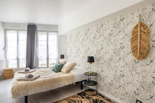 una camera con letto e parete con carta da parati di OIQIA • Téralis • Estival ad Annonay