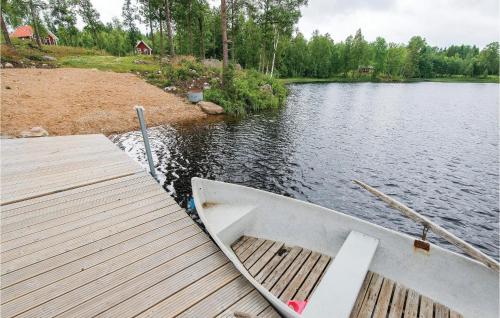a boat parked at a dock on a lake at Stunning Home In Holmsjö With Kitchen in Holmsjö