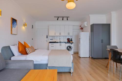 a bedroom with a bed and a couch and a kitchen at Körfez Residence in Fethiye