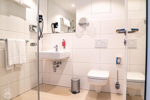 a bathroom with a toilet and a sink at Hotel am Borsigturm in Berlin