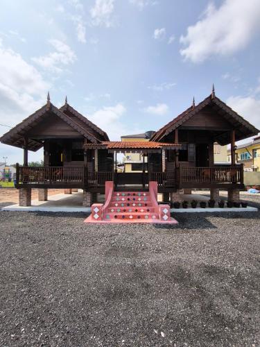 a playground with a pink bench in front of a building at Balam Inn Homestay & Chalet in Kampong Kebun Baharu