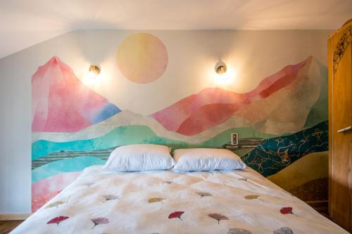 a bedroom with a mural of mountains on the wall at Gîte le Belvezou - Charmante maison de campagne in Vézins-de-Lévézou