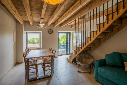 - un salon avec une table et un canapé vert dans l'établissement Gîte le Belvezou - Charmante maison de campagne, à Vézins-de-Lévézou