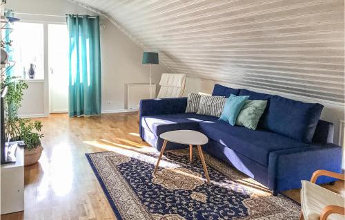 a living room with a blue couch and a table at Nice Home In Gislaved With Sauna in Gislaved