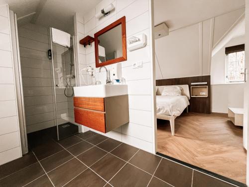 a bathroom with a sink and a mirror at Hotel de Zeeuwse Stromen - Duinpark in Renesse