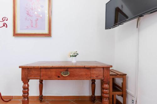 a wooden table with a vase of flowers on top at Ponte Vecchio Comfort Apartment in Florence