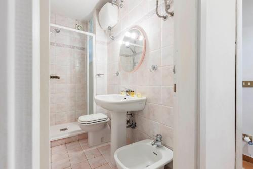 a white bathroom with a sink and a toilet at Ponte Vecchio Comfort Apartment in Florence