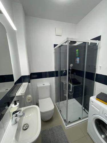 a bathroom with a shower and a toilet and a sink at ComeWa Apartments in Warsaw
