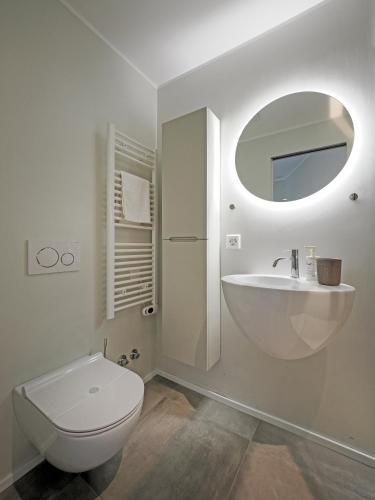 a white bathroom with a toilet and a sink at Appartamento Food Truck 11 in Muralto