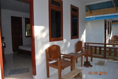 a room with two chairs and a table and a porch at Tangkoko Macaca in Rinondoran