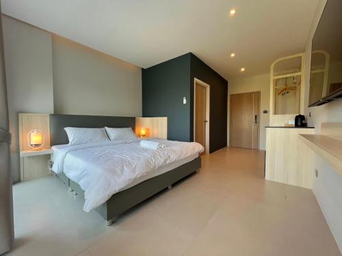 a bedroom with a large bed with two lamps on it at The Way Hotel Ban Pong in Ban Pak Raet