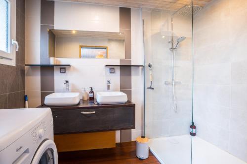 La salle de bains est pourvue de 2 lavabos, d'une douche et d'un lave-linge. dans l'établissement Le Ferdinand - Appt lumineux centre-ville Vannes, à Vannes