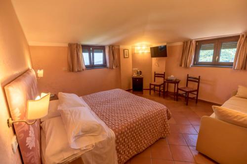 a bedroom with a bed and a table and chairs at Villa Romita in SantʼAgata sui Due Golfi
