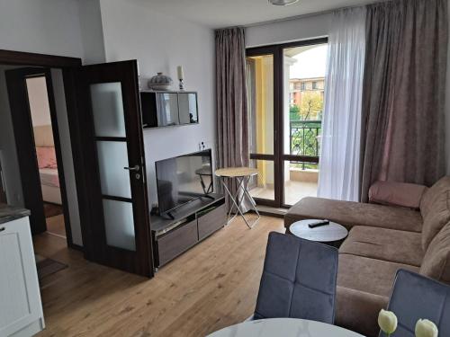 a living room with a couch and a television at Domus Extra Apartments in Sveti Vlas