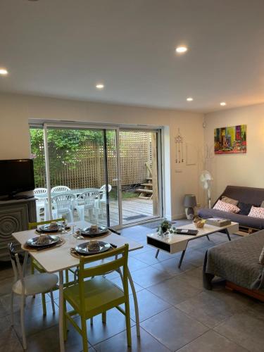 un salon avec une table, des chaises et un canapé dans l'établissement Landes Appart, à Labenne