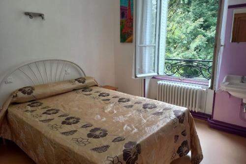 une chambre avec un lit et une fenêtre dans l'établissement Villa le bois Joli, à La Bourboule