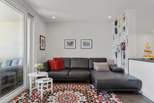 a living room with a black leather couch and a rug at Apartment Concha in Dugi Rat