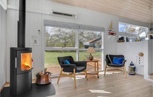 a living room with a fireplace and two chairs at Holiday Home Lyngsbækvej Ix in Ebeltoft