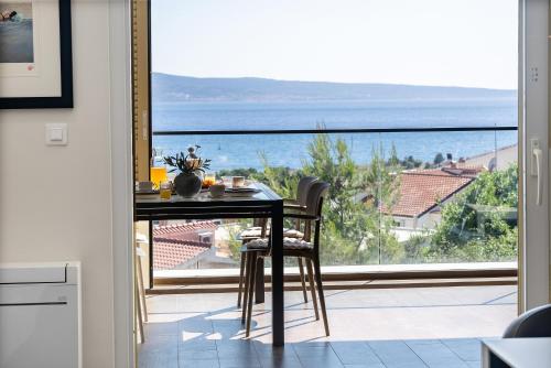 a dining room table with a view of the ocean at Apartment Concha in Dugi Rat