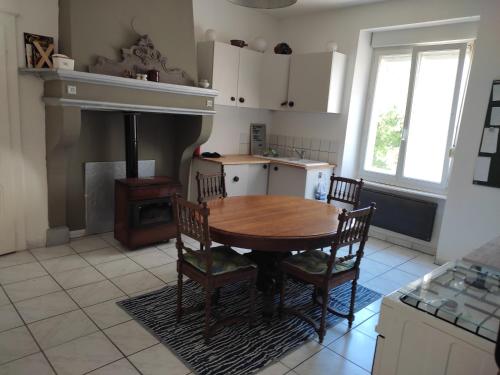 a kitchen with a table and chairs and a stove at La Slow Life in Saint-Maurice-sous-les-Côtes