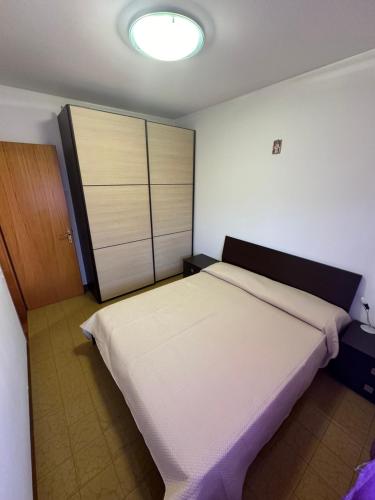 ein Schlafzimmer mit einem großen Bett und einem Schrank in der Unterkunft Residence Armor - Agenzia Cocal in Caorle