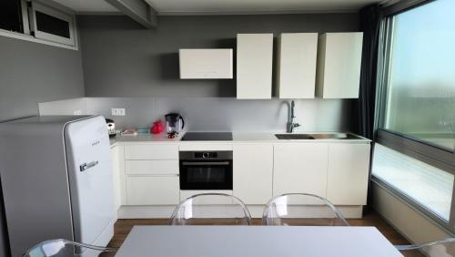 une cuisine avec des armoires blanches et une table et des chaises dans l'établissement Vue Mer Exceptionnelle, à Marseillan