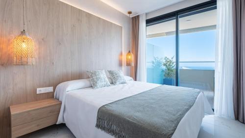 a bedroom with a large bed and a large window at Benidorm Beach, Grupo AMI in Benidorm