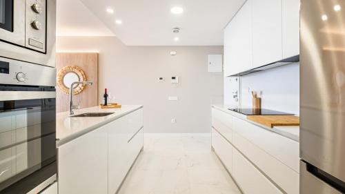 a white kitchen with white cabinets and a sink at Benidorm Beach, Grupo AMI in Benidorm