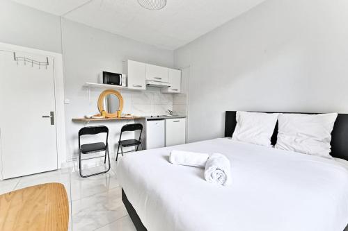 une chambre blanche avec un lit et une cuisine dans l'établissement Agréable Studio #Montmartre #SacréCœur, à Paris