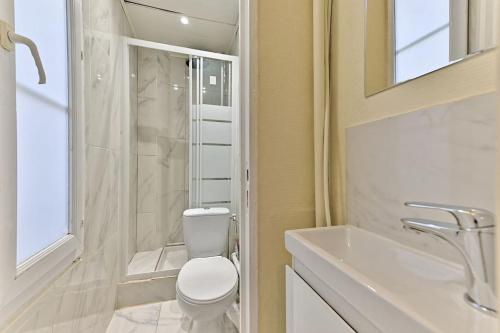 une salle de bain blanche avec des toilettes et un lavabo dans l'établissement Agréable Studio #Montmartre #SacréCœur, à Paris