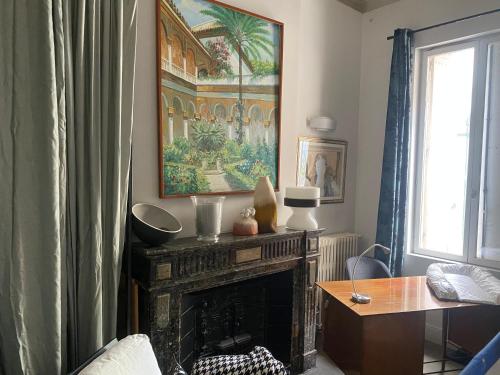 un salon avec une cheminée et un tableau au mur dans l'établissement Appartement Sète, à Sète