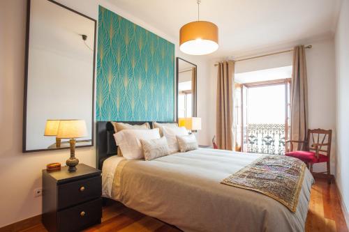 リスボンにあるBairrus Lisbon Apartments - Cathedralの青い壁のベッドルーム1室(大型ベッド1台付)