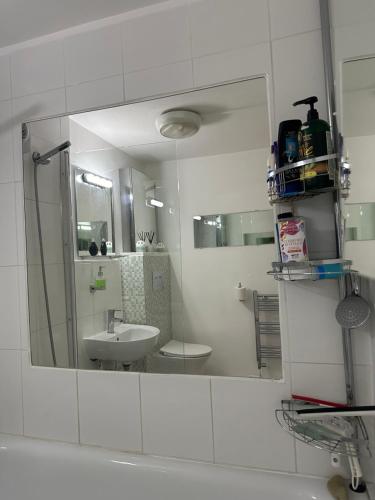 a white bathroom with a sink and a mirror at Alexandra Palace White Hart Lane Twin room in London