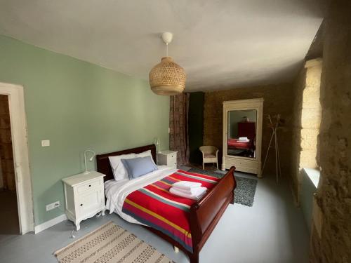 une chambre avec un lit et un miroir dans l'établissement Cozy town centre cottage, à Beaumont-du-Périgord