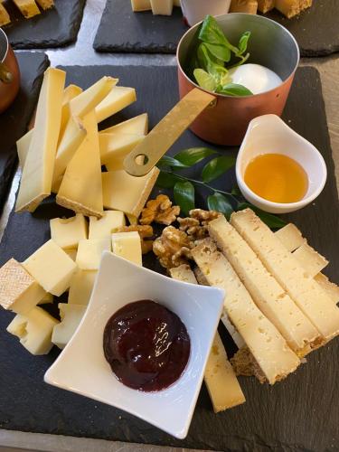 a plate of cheese and other food on a table at Hotel Maloia in Dubino