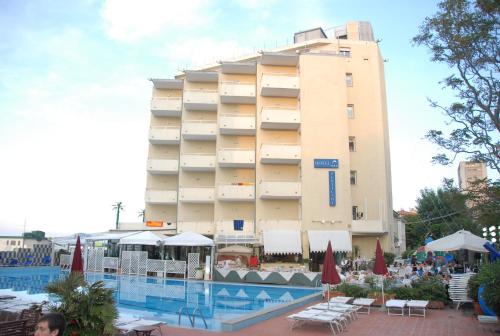 un hotel con piscina frente a un edificio en Perticari en Pesaro