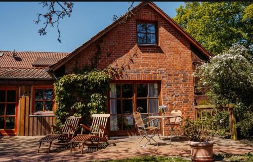 a brick house with chairs and a table in front of it at Ferienhof Trapp in Ellringen
