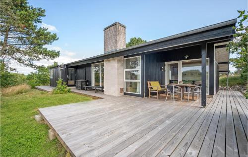 a house with a wooden deck with a table at Holiday Home Ebeltoft 18 in Ebeltoft