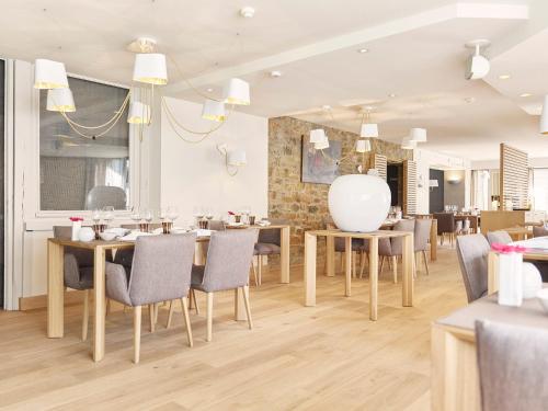 a dining room with wooden tables and chairs at Hotel Le Beau Séjour in Nassogne