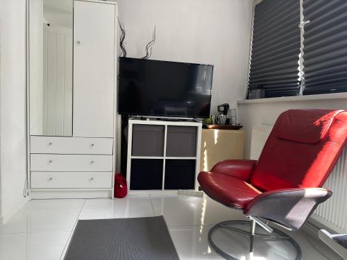 a living room with a red chair and a television at Alexandra Palace White Hart Lane Twin room in London