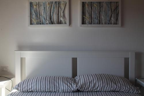 a bed in a bedroom with two pictures on the wall at b&b U Punenti in La Maddalena