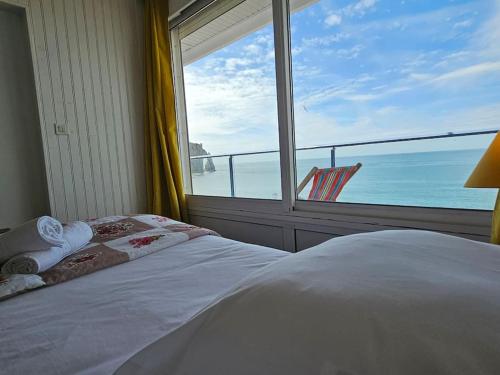 - une chambre dotée d'une fenêtre offrant une vue sur l'océan dans l'établissement L'idéal, appartement vue mer, à Étretat