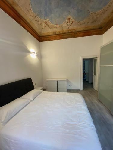 a bedroom with a large white bed with a ceiling at Brera's Elite Apartment in Milan