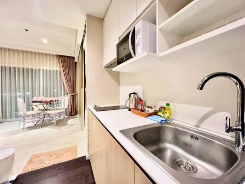a kitchen with a stainless steel sink and a toilet at Veranda Residence Jomtien Beach Pattaya in Na Jomtien