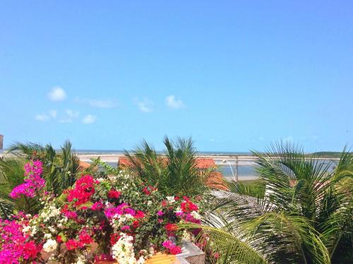 a view of the beach from a balcony with flowers at Pousada Recanto do Sal in Salinópolis