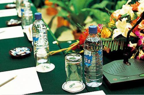 a table with two bottles of water and a laptop at Golden Bay Hotel Weihai in Weihai