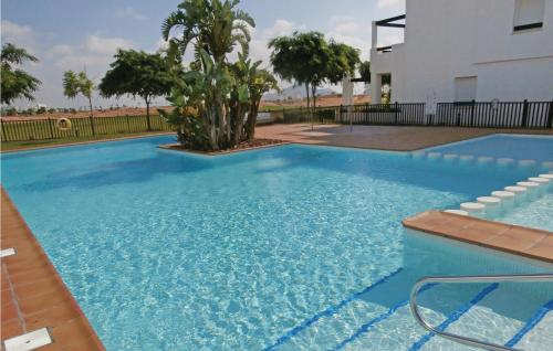 a large swimming pool with blue water at 2 Bedroom Lovely Apartment In Roldán in Las Pedreñas